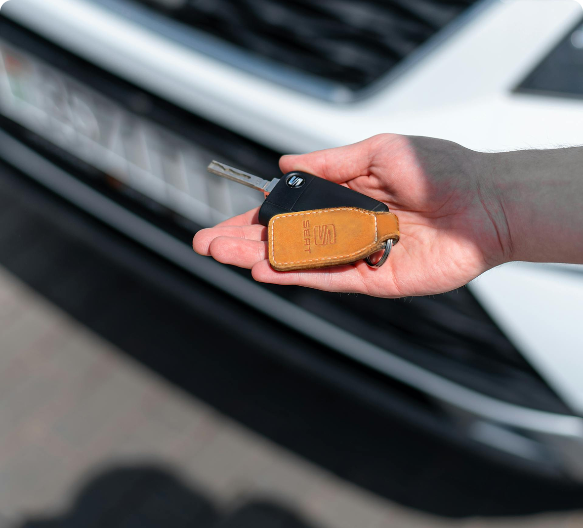 A person holding keys to a car